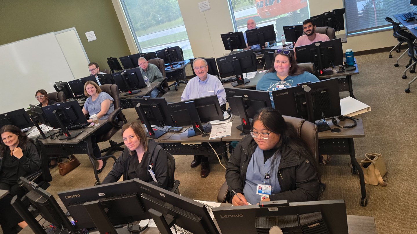 Outpatient primary care providers smiling at their workstations during an Epic training class